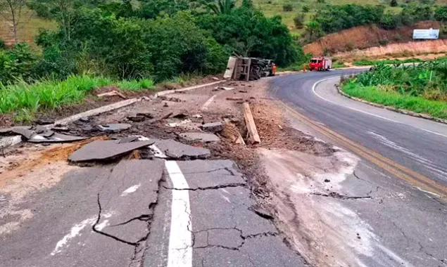 Caminhão carregado de pedras tomba e provoca rachaduras em asfalto 